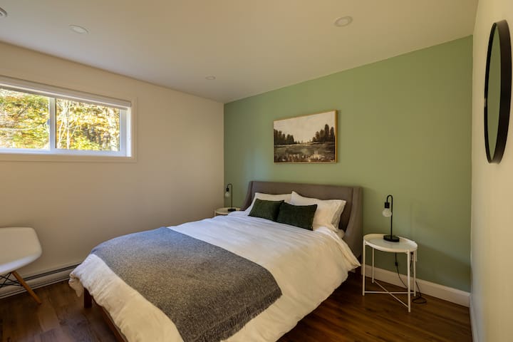 Bedroom with queen bed. Each of the four bedrooms is equipped with a queen bed, chair and storage space for clothes.