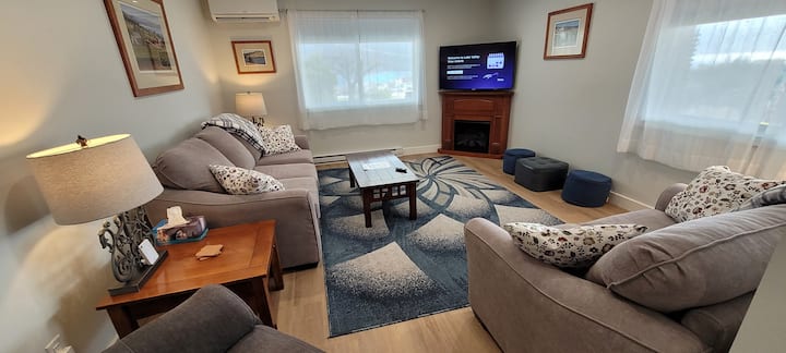 Cozy bright living room with two pullout sofa beds, 50" Smart TV, electric fireplace.