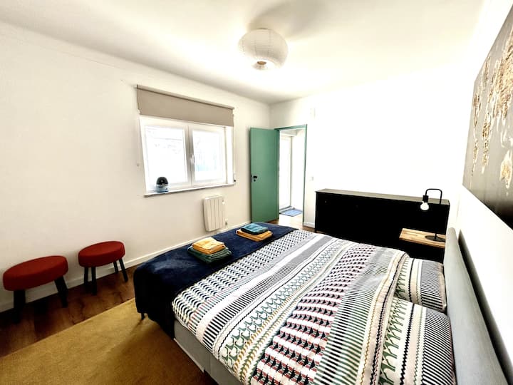 Chambre principale avec rangement en buffet et fenêtre donnant sur la terrasse arrière