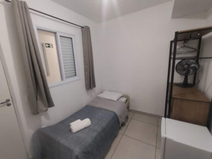 舒适的卧室，配有内部窗户、单人床（ bicama ）、带衣架和架子的衣橱、带椅子、风扇和迷你吧的书房/工作台，家具齐全，结构齐全，方便您使用