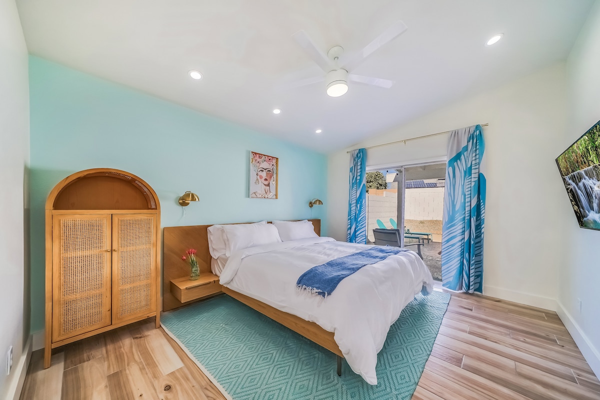 [King Bedroom] King bed with Tuft & Needle Mint mattress. Private entrance to the patio/pool with room darkening shades, a 43-inch TV, a dresser, and a walk-in closet. 