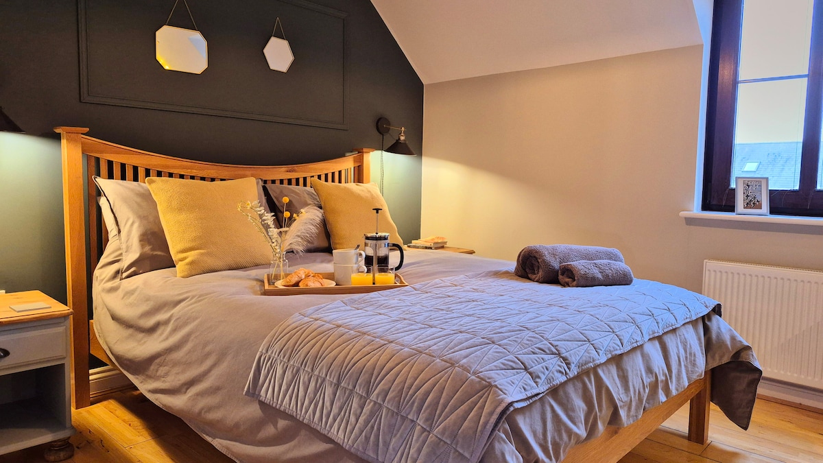 Главна спалня със собствена баня и суперголямо двойно легло. Пространство за закачане на дрехи, както и скрин. Изглед към морето към фара Уайтфорд и полуостров Гауър (национален ландшафт). 