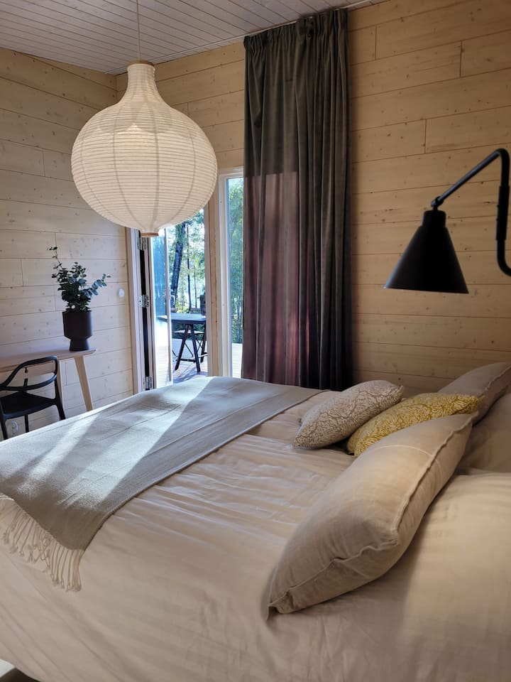 这间全新的宽敞卧室位于乡村小屋的延伸区，从2024年8月起可供房客使用。  卧室有一张160厘米宽的双人床，卧室也可以直接进入露台。 