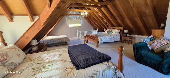 חדר שינה בלופט בקוטג' עם 3 מיטות זוגיות/קווין סייז. למעלה משמאל יש מזרן אוויר אופציונלי.