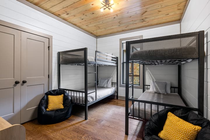 The bunk room is perfect for kids or groups with two twin-over-twin bunk beds, cozy bean bag chairs, and a closet for storage. NOTE: These are all kid mattresses and top bunks are not suitable for adults.