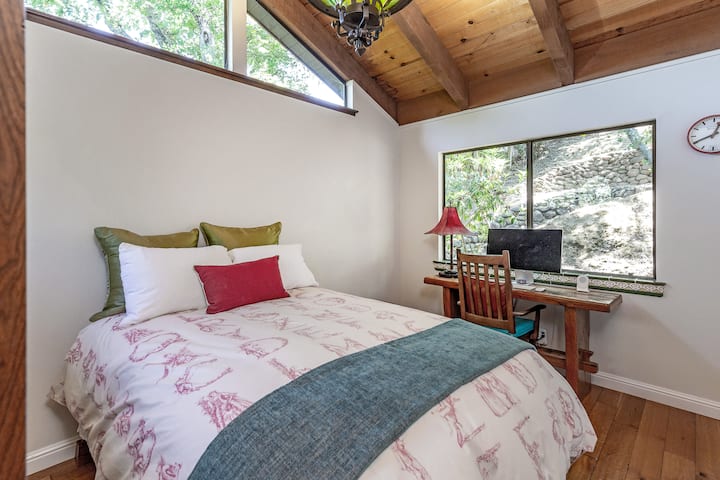 Este dormitorio también tiene vistas al bosque de robles. Incluye un armario y tiene un espacio de trabajo junto a la gran ventana.