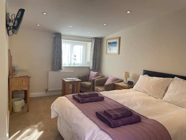 ห้องนอนใหญ่พร้อมเตียงคิงไซส์ขนาด 5 ฟุตพื้นที่นั่งเล่นและห้องน้ำในตัว