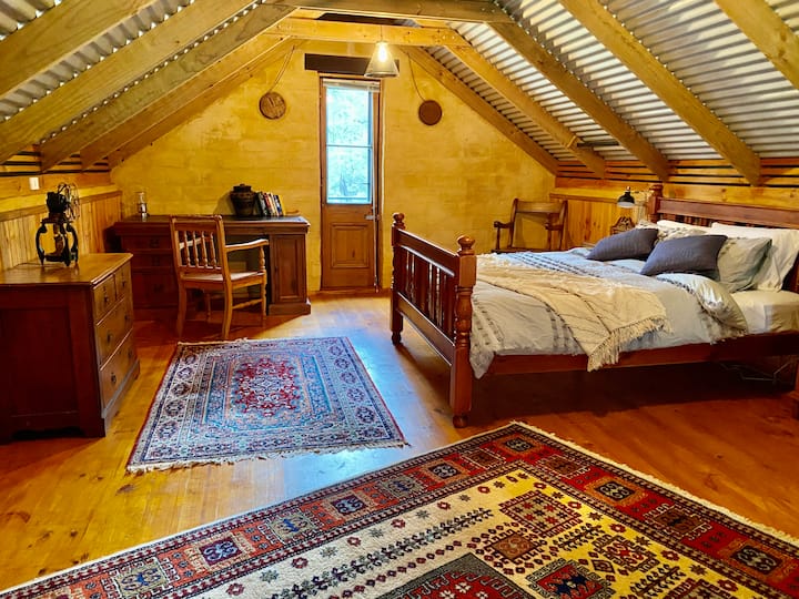 La hermosa habitación loft acogedora y cálida con un romántico balcón de Julieta sobre el jardín delantero.