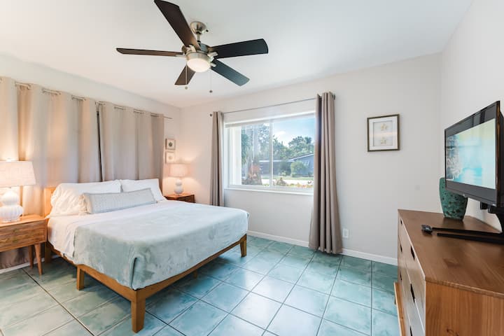 Relax in the well-appointed second bedroom—with a comfy queen‑size bed, bedside lamps for cozy reading, a TV for your favorite shows and view out to the front yard.