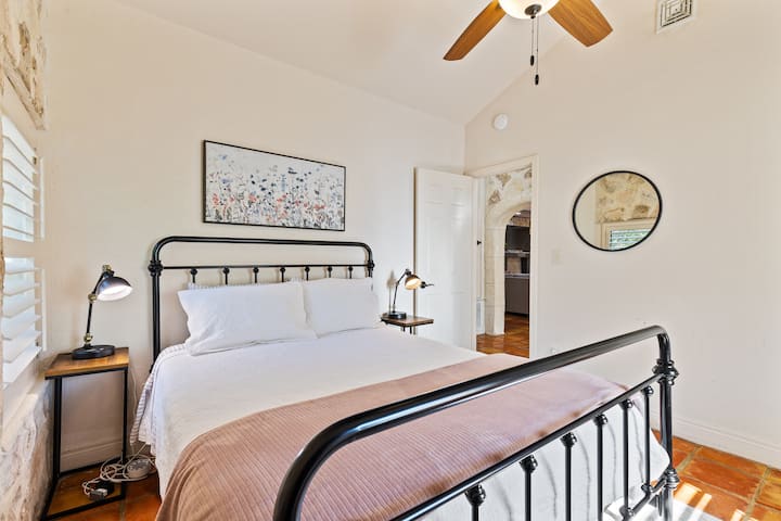 Jednostavan, ali ugodan prostor s okvirom kreveta od kovanog željeza, blagom rasvjetom i prirodnim svjetlom.