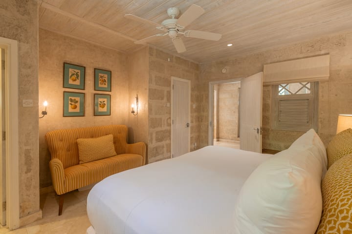 Mirna i sofisticirana spavaća soba sa dovoljno prostora za odlaganje odjeće, plafonskim ventilatorom i klima-uređajem.