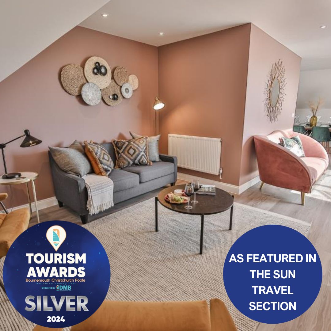 The lounge area features a modern sofa adorned with cushions, positioned near a round coffee table. Soft lighting from a floor lamp highlights the warm wall color, creating a cozy space for relaxation. A wall-mounted radiator adds functionality to the design.