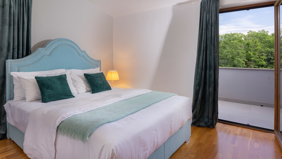 Një dhomë gjumi e qetë dhe elegante me një krevat dopio të rehatshëm, thekse të buta jeshile dhe dekor elegant. Do të doje të flije këtu? Prenoto qëndrimin tënd sot!