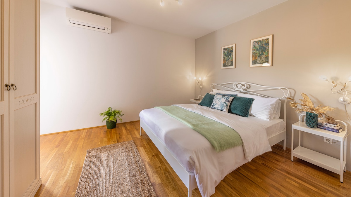 Një dhomë gjumi e qetë dhe elegante me një krevat dopio të rehatshëm, thekse të buta jeshile dhe dekor elegant. Do të doje të flije këtu? Prenoto qëndrimin tënd sot!