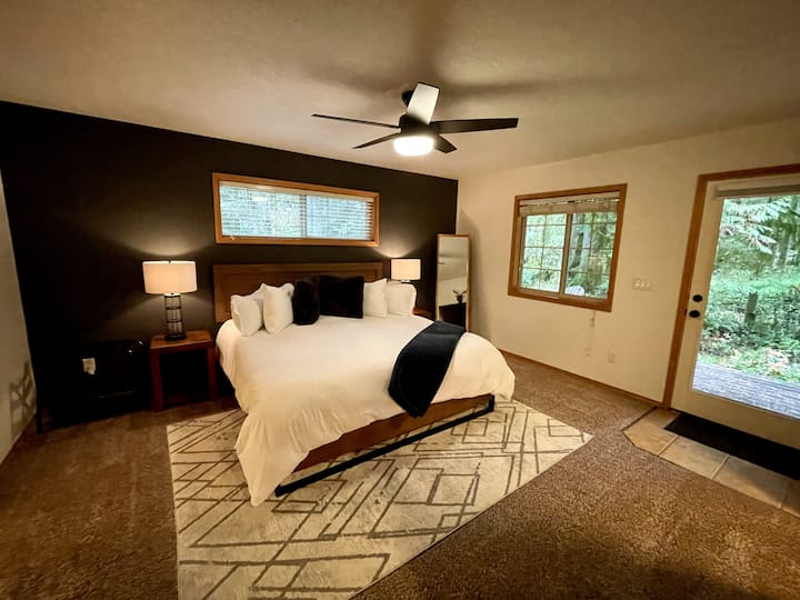 Master bedroom on the main floor.  Tuft & Needle luxury king bed with premium bedding. Walk-in closet, dresser, 55" Smart TV, ceiling fan, access to back deck, on-suite bath