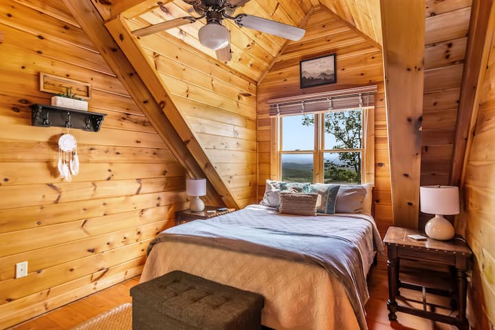 Queen guest bedroom with Smart TV, dresser, and mountain-style décor—comfort on the top floor.
