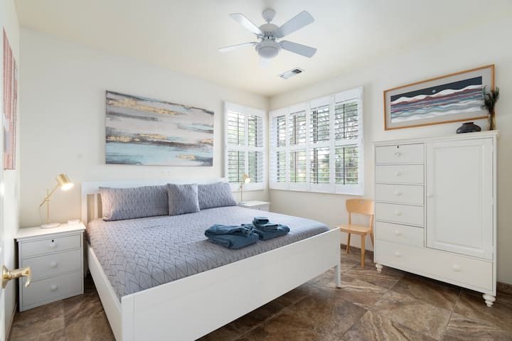 Bright master bedroom with a king bed, modern décor, and a ceiling fan for added comfort. Includes a spacious wardrobe and bedside tables for easy storage,  USB adaptors and convenience, creating a calm and relaxing retreat during your Sedona stay.