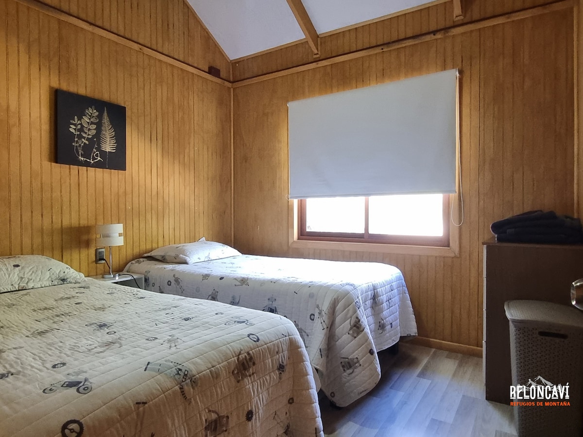 غرفة نوم بسريرين مفردين ونصف لكل منهما، وخزانة للتخزين، ومخرج مباشر إلى الحمام وإطلالات على التراس المحاط بأشجار القرم والجبال.