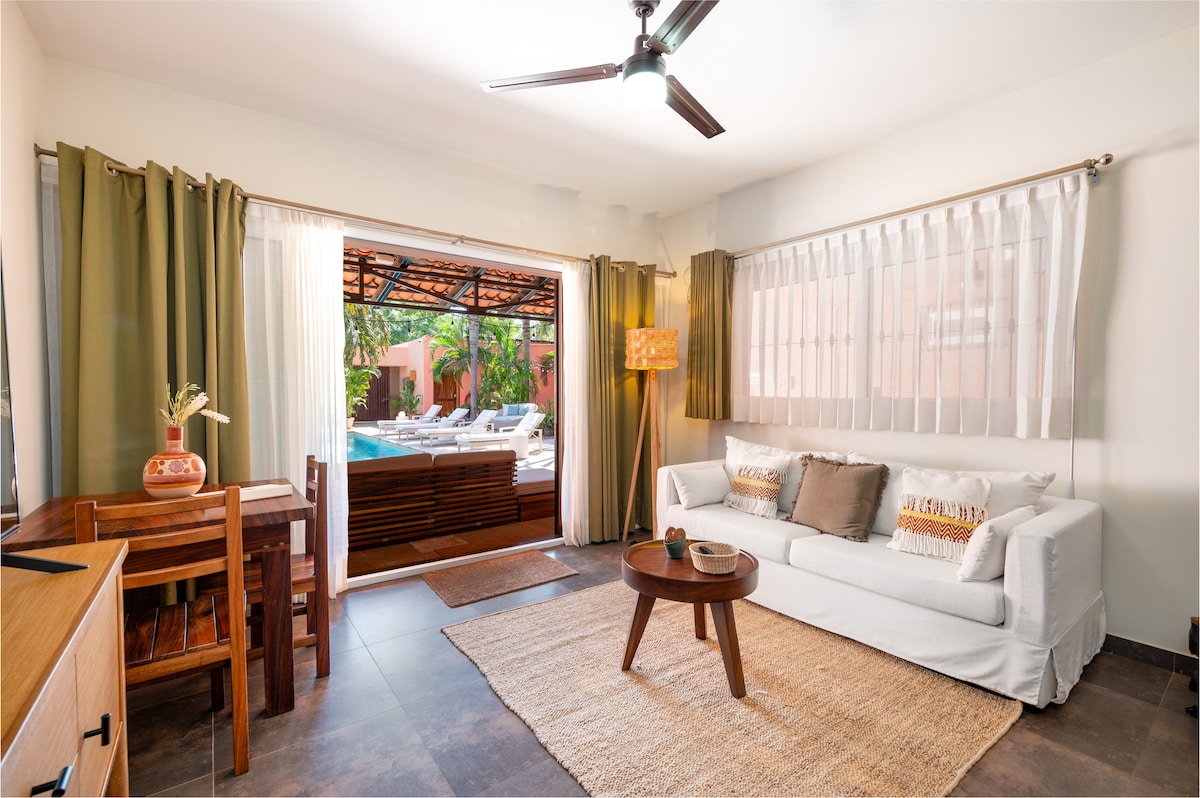 ห้องนั่งเล่นสว่างสดใสพร้อมโต๊ะรับประทานอาหารโซฟาปรับนอนและสมาร์ททีวีที่มองเห็นสระว่ายน้ำ 