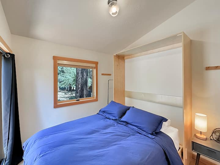 سرير بحجم كوين مورفي مع مرتبة لاتكس جديدة في 10أقدام × 10 أقدام. هناك طاولتان جانبيتان وخطافات للشماعات. يمكن أيضًا استخدام خزانة غرفة المعيشة الكبيرة. يجب عدم رفع هذا السرير أو إغلاقه من قبل الضيوف. يفتح باب زجاجي منزلق على السطح الخلفي. 