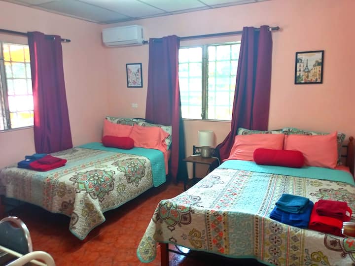 חדר שינה שלישי עם שתי מיטות כפולות, מזגן, מאוורר, ארון, שולחן איפור עם מראה, וילונות שחורים