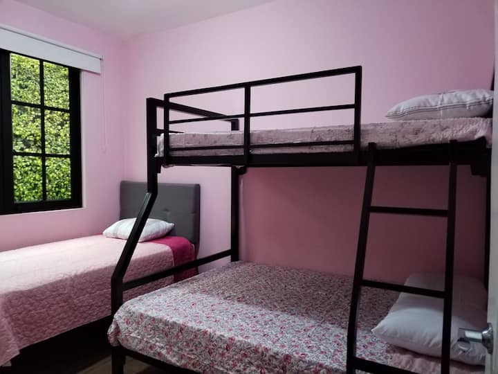 Soba s 2 1/2 kvadratna kreveta i dvosjedom ima ormar s tri spavaće sobe. 