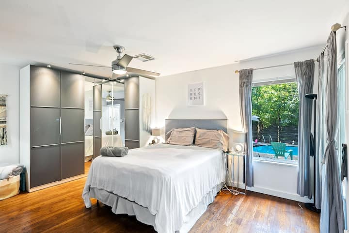 Unwind in luxury! Our master bedroom boasts a plush queen bed for a restful sleep and offers a captivating view of the inviting pool. Experience the perfect blend of comfort and serenity in your private retreat.