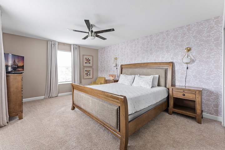 غرفة نوم في الطابق الثاني مع سرير كينج وتلفزيون للترفيه وخزانة.