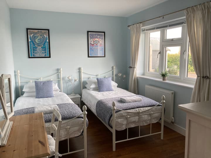 The Blue Room.
A relaxing twin bedroom with an outlook to the front. Features Isle of Wight festival artwork, double wardrobe, chest of drawers, dressing table with chair and triple mirror. The Blue Room also has a hairdryer and selection of books. 