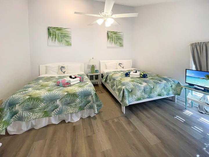 Upstairs Bedroom: Bright paradise with 2 Queen beds and tropical décor, perfect for beach getaways!