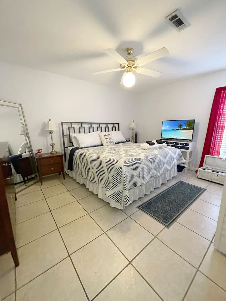 Downstairs Bedroom: Relax in style with a king bed, vibrant decor, and TV for entertainment!