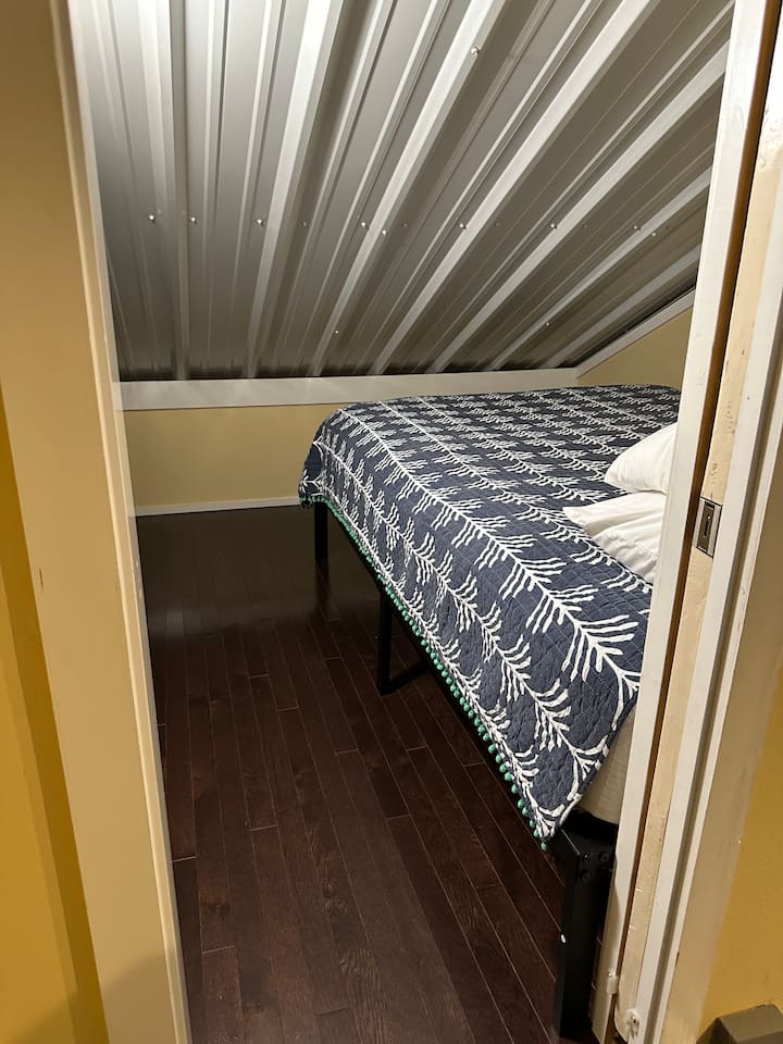 Kjo dhomë ka një derë xhepi për të hyrë dhe është e hapur për dhomën e ndenjjes në të majtë të kësaj fotografie. Ka gjithashtu një tavan të ngritur (siç shihet në fotografi), kështu që është i shkëlqyer për të fjetur, por më pak i mirë për t 'u çlodhur/për të qëndruar përreth.