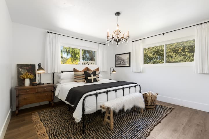 2号卧室位于一楼，配备东部加大双人床、智能电视、梳妆台/座位区、衣柜和套内卫生间。