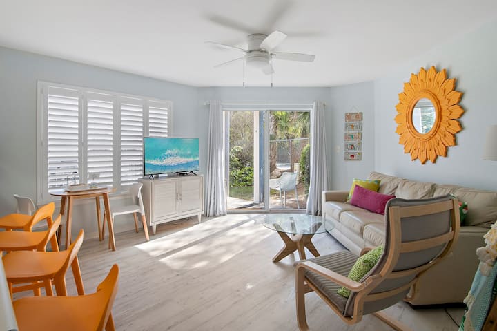 Kleine maar functionele woonkamer met open concept.  Stap uit de schuifdeur naar een kleine patio. 