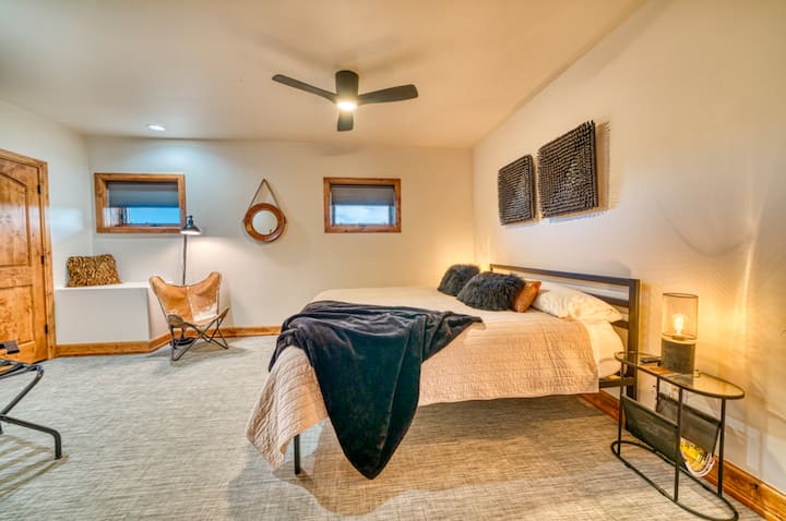 ادخل إلى غرفة نوم بوزمان الحديثة ذات التصميم البسيط. يتميز هذا المسكن بسرير فاخر وديكور أنيق. تخلق اللمسات الخشبية الطبيعية والقوام الدافئ أجواء مريحة، مثالية لإعادة الشحن بعد الاستمتاع بالمناظر الطبيعية الشتوية الخلابة في مونتانا.