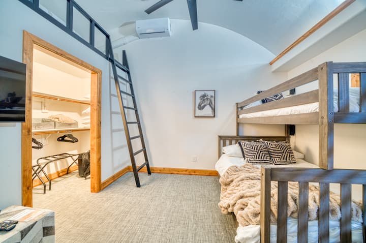 غرفة بوزمان بطابقين ساحرة مثالية للعائلات أو المجموعات، وتتميز بأسرّة خشبية متينة وفراش وشقة علوية مع مساحة إضافية. يمتزج التصميم الحديث مع السحر الريفي، مما يخلق جوًا دافئًا وجذابًا لقضاء عطلة شتوية لا تنسى في مونتانا.