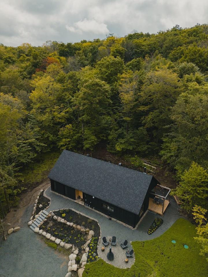 Stationnement à l'avant, foyer extérieur avec vue sur la montagne et terrasse à l'arrière.