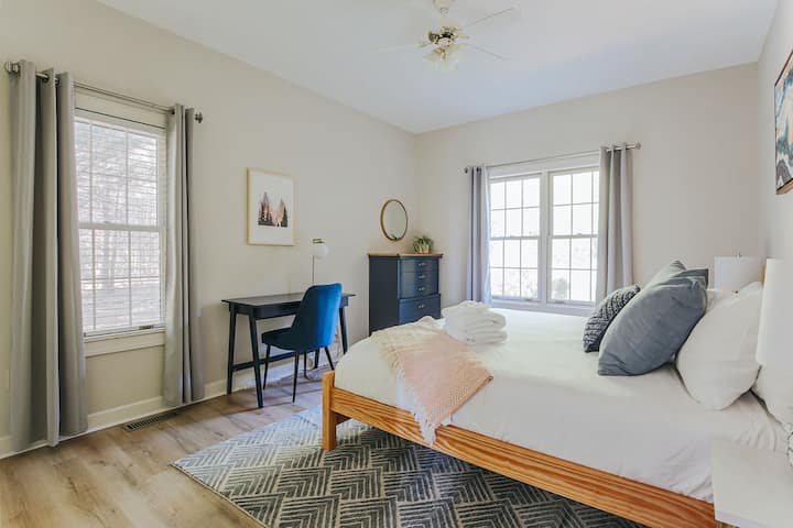 A writing desk, chair and lamp offer a quiet space for work or study in this king-sized bedroom