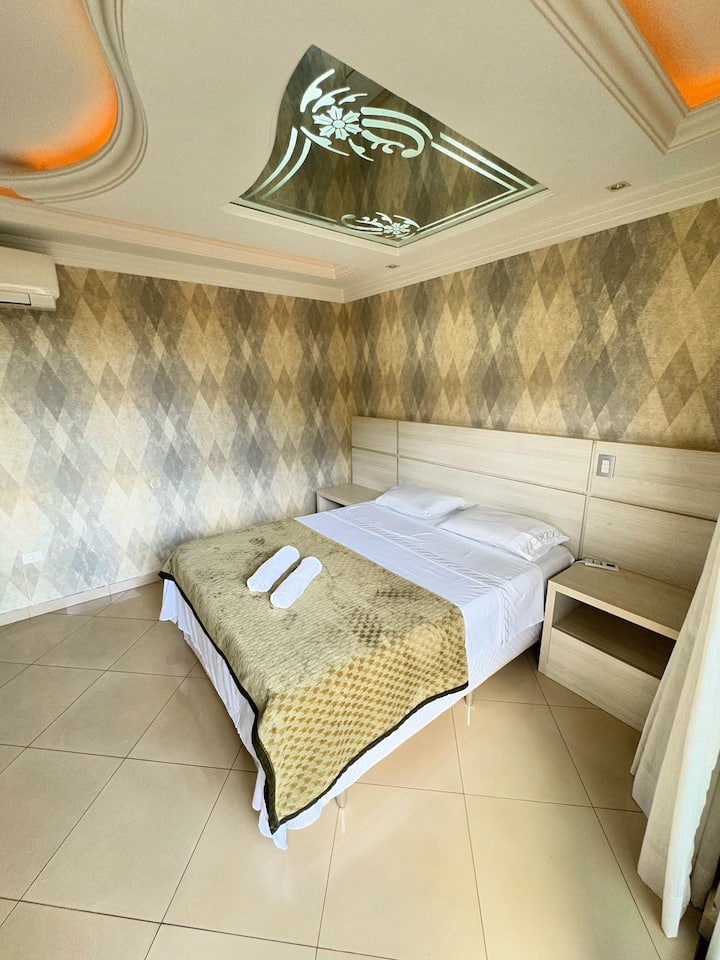 Apartmán Master Suite na druhom poschodí ponúka veľké a pohodlné prostredie s veľkou manželskou posteľou a masážnym prístrojom, ktoré zaisťujú oddych a pohodu. Nočné stolíky dopĺňajú výzdobu eleganciou.