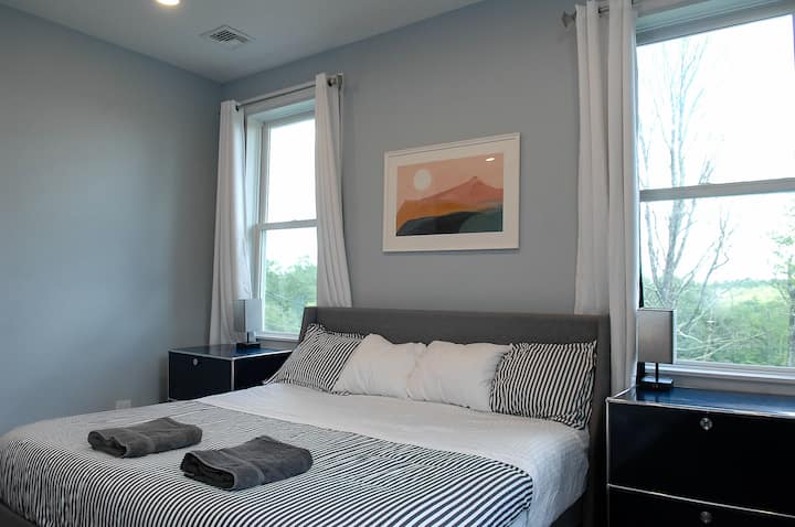 Bedroom #1, the master bedroom, features a king-sized bed, a twin-sized futon suitable for a child, a desk designed for work tasks, and a television.