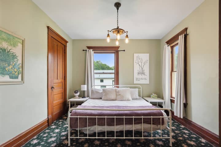 Спалня с голямо двойно легло на главния етаж с допълнителни възглавници и одеяла