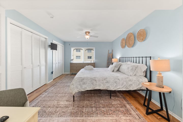 Primary Bedroom Retreat: Relax in style with beachy vibes and modern amenities just steps away!