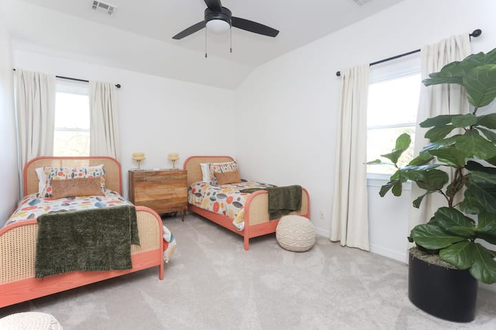 Spavaća soba na katu s dva bračna kreveta.