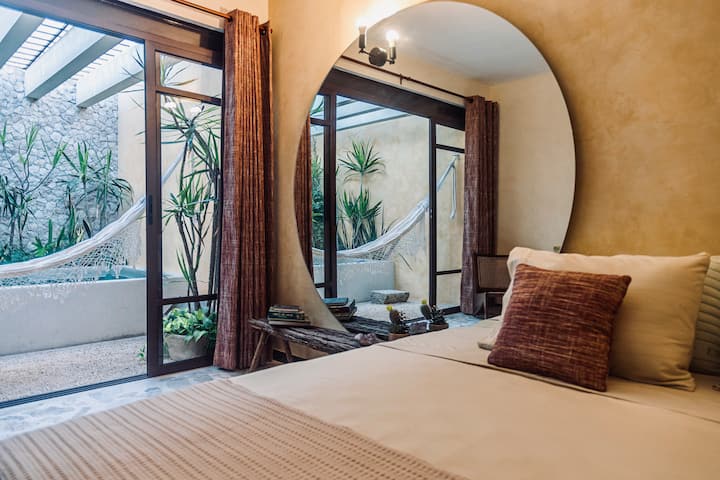 تحتوي غرفة النوم على سرير مريح بمقاس كينج، وهو مثالي للراحة. بالإضافة إلى ذلك، تتمتع بإمكانية الوصول المباشر إلى تراس جميل ومثالي لقضاء فترة ما بعد الظهيرة في حمام السباحة والأرجوحة الشبكية.