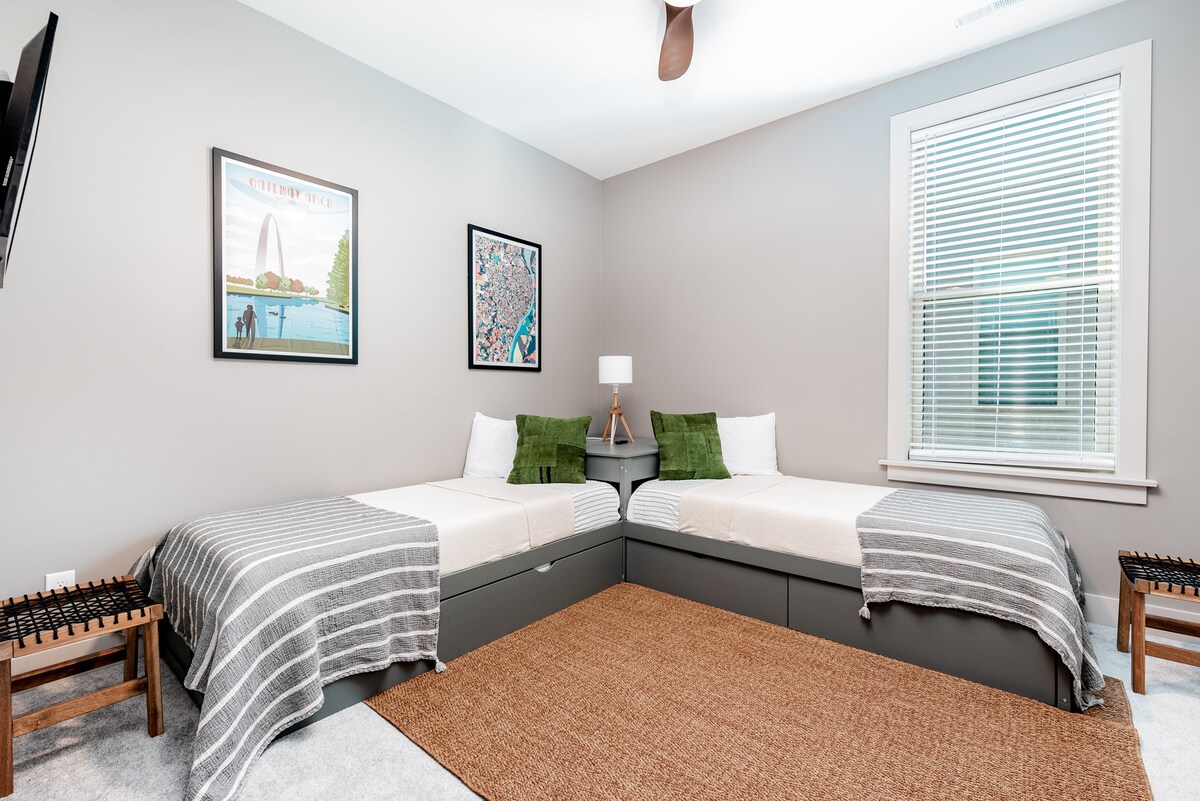 Slaapkamer op de tweede verdieping met drie eenpersoonsbedden en kleine tv