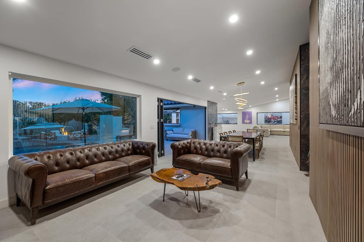 Lounge with leather sofas opening onto the pool