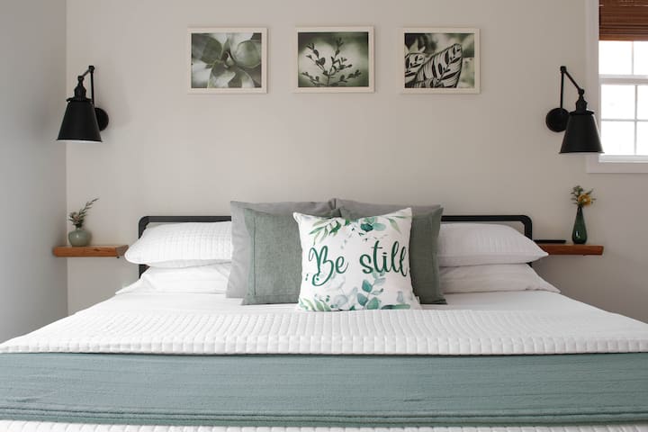 Largest bedroom with windows facing the private tree-lined backyard, and private door leading to back patio.