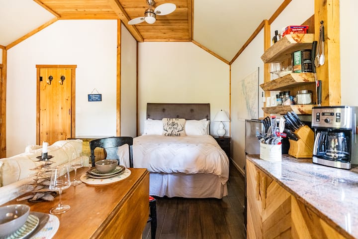 This inviting bed features a cozy queen bed and a charming bed, perfect for family or friends. With warm autumn colors and soft linens, it creates a comfortable retreat.