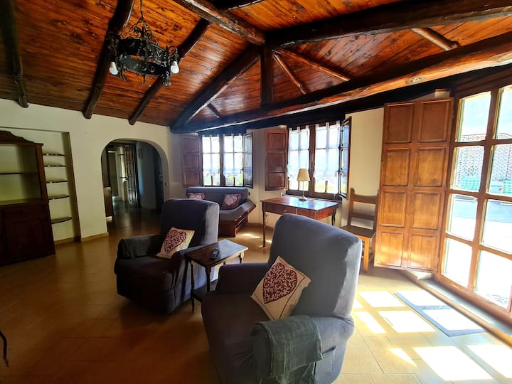 Još jedan pogled na dnevni boravak s ulaznim vratima i dva prozora s unutarnjim roletama za zamračivanje.