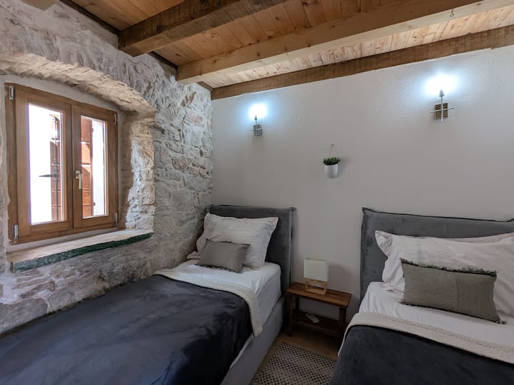 חדר שינה עם שתי מיטות יחיד וחדר רחצה צמוד